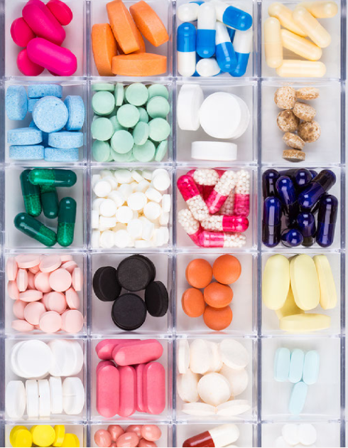 Collection of colorful pills arranged in a pill box